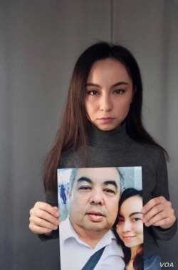 Exiled Uyghur Samira Imin holds a picture of her father, Iminjan Seydin, who went missing in April 2017 in China's Xinjiang region.