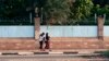 FILE - Two women walk, one freely without a headscarf, in the Sudanese capital Khartoum, Aug. 27, 2019. 