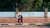 FILE - Two women walk, one freely without a headscarf, in the Sudanese capital Khartoum, Aug. 27, 2019. 