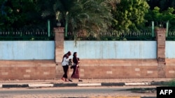 FILE - Two women walk, one freely without a headscarf, in the Sudanese capital Khartoum, Aug. 27, 2019. 