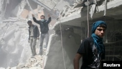People search for survivors in the rubble of a damaged area that activists said was a result of an airstrike by the Syrian regime, in the Al-Sukkari neighborhood in Aleppo, Syria, April 7, 2013.