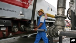 FILE - A worker refuels a truck at a fuel storage depot in Jakarta, Indonesia.