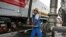 FILE - A worker refuels a truck at a fuel storage depot in Jakarta, Indonesia.