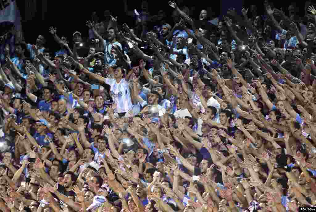 แฟนบอลชาวอาร์เจนตินาส่งเสียงเชียร์ทีมบอลของตนระหว่างการแข่งขันฟุตบอล Copa Libertadores soccer match ระหว่างอาร์เจนตินา Racing Club กับปารากวัย Paraguay Guarani กรุงบูเอโนสไอเรส