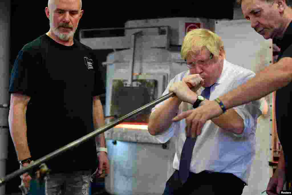 Britain&#39;s Prime Minister Boris Johnson blows glass prior to chairing a cabinet meeting at the National Glass Centre at the University of Sunderland, Sunderland, Britain.