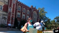 Kellie Dick, left, a University of Oklahoma senior from Shawnee, Okla., and Abhi Nath, a senior from Norman, voice their concerns about OU's handling of the coronavirus pandemic during a student demonstration, Sept. 3, 2020, in Norman, Okla. 