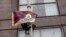 A demonstrator holding a Free Tibet flag climbs a flagpole outside the hotel where China's President Xi Jinping will meet with U.S. business leaders, on the sidelines of the APEC summit, in San Francisco