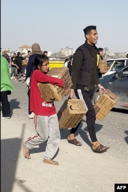 طیاروں سے گرائے گئے خوراک کے پارسل حاصل کرنے میں کامیاب ہونےوالے فلسطینی نوجوان ۔ یہ تصویر اے ایف پی ٹی وی کی ویڈیو سے لی گئی ہے۔ اے پی ، دو مارچ، دو ہزار چوبیس