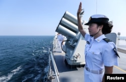 FILE - A Chinese soldier waves farewell to Russian fleets as the Chinese-Russian joint naval drill concludes in Zhanjiang, Guangdong Province, China.