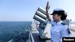 FILE - A Chinese soldier waves farewell to Russian fleets as the Chinese-Russian joint naval drill concludes in Zhanjiang, Guangdong Province, China.