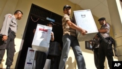 Cảnh sát vũ trang đứng canh gác trong lúc các giới chức bầu cử mang hòm phiếu đến phân phối cho các trạm bỏ phiếu địa phương tại Banda Aceh, Indonesia, ngày 8/4/2014.