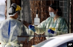 Medical staff prepare to take a COVID-19 tests at a drive through community based assessment centre in Christchurch, New Zealand, Aug. 13, 2020.