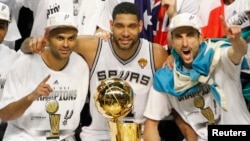 Para pemain San Antonio Spurs (dari kiri ke kanan) Tony Parker dari Perancis, Tim Duncan, Manu Ginobili dari Argentina, berfoto bersama piala kejuaraan NBA, Juni 2014.