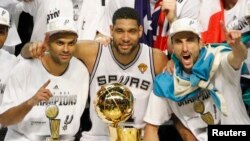 Tony Parker de la France, Tim Duncan, Manu Ginobili de l'Argentine, tous joueurs de San Antonio Spurs posent avec le trophée Larry O'Brien après la victoire des Spurs sur le Heat de Miami à San Antonio, Texas, 15 juin 2014. 