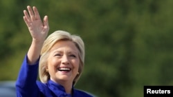 ຜູ້ລົງແຂ່ງຂັນເອົາຕຳແໜ່ງປະທານາທິບໍດີ ຈາກພັກເດໂມແຄຣັດ ທ່ານນາງ Hillary Clinton ຍົກມືທັກທາຍໃນຂະນະທີ່ທ່ານນາງ ເດືອນທາງຂຶ້ນເຮືອບິນໂຄສະນາຫາສຽງຂອງທ່ານາງ ທີ່ສະໜາມບິນເຂດ Westchester ໃນເມືອງ White Plains, ລັດນິວຢອກ. 21 ກັນຍາ 2016.