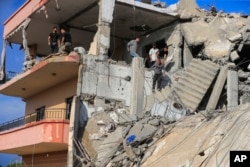 People search for victims at a building hit in an Israeli airstrike, in Ghaziyeh, south Lebanon, Nov. 3, 2024.