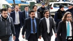 土耳其軍人在希臘警察陪同下走進法庭。