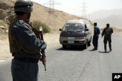 Afghan police officers search a vehicle at a checkpoint on the Ghazni highway, in Maidan Shar, west of Kabul, Afghanistan, Aug. 13, 2018.