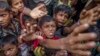 Rohingya Muslim children, who crossed over from Myanmar into Bangladesh, stretch out their arms out to collect chocolates and milk distributed by Bangladeshi men at Taiy Khali refugee camp, Bangladesh, Sept. 21, 2017. 