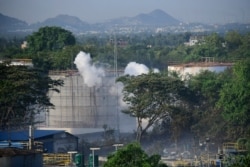 Smoke rises from LG Polymers plant, the site of a chemical gas leakage, in Visakhapatnam, India, May 7, 2020. Synthetic chemical styrene leaked from the industrial plant in southern India.