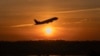 The sun rises and a jet lifts off above a wreckage site in the Potomac River from Ronald Reagan Washington National Airport, Feb. 3, 2025, in Arlington, Va.