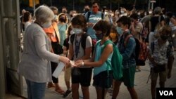 Estudiantes españoles usan mascarilla y se desinfectan las manos para protegerse del coronavirus al entrar a la escuela el 14 de septiembre de 2020.