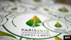 FILE - Stickers with emblem of Climate Change Conference 2015, slated to kick off Nov. 30 in Paris.