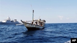 FILE - A handout picture received from The Netherlands Ministry of Defence shows a boat containing alleged Somali pirates being apprehended by Netherlands warship Evertsen.