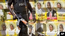 Polisi anti huru-hara berpatoli di sekitar poster kampanye Presiden Yoweri Museveni, di Kampala, Uganda (Foto: dok).