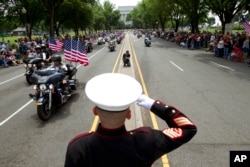 FILE - U.S. Marine Tim Chambers salutes to participants in the Rolling Thunder motorcycle rally ahead of Memorial Day on May 27, 2018, in Washington.