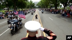 U.S. Marine Tim Chambers salutes to participants in the Rolling Thunder motorcycle rally ahead of Memorial Day on May 27, 2018, in Washington. 