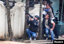 A police officer points his weapon near a government office following an explosion in Bandung, West Java, Indonesia, Feb. 27, 2017.