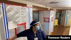 Nurse Katelyn Sofley stands at the entrance to a negative pressure ICU hospital room, where COVID-19 patients are treated, at St John's Regional Medical Center in Oxnard, California, July 9, 2020. The state is seeing a surge of coronavirus patients.