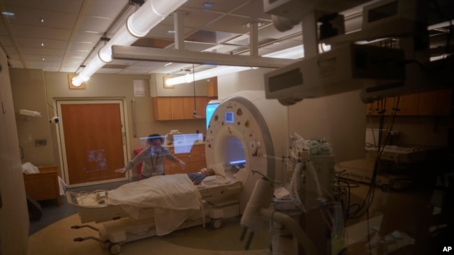 Charlie Stroiney, 8, is prepped for an MRI during a long day of testing at Children's National Hospital, in Washington. Charlie did not have COVID-19 but her sister, Lexie, 6, did.