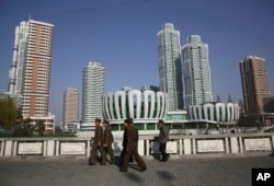 North Koreans walk past Ryomyong Street, the newest residential development in Pyongyang, North Korea, April 11, 2017. North Korean Premier Pak Pong Ju told the Supreme People's Assembly that a priority for the Cabinet this year would be improving the cou