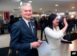 Former banking adviser Gitanas Nauseda, a presidential candidate, and his wife, Diana Nausediene, right, arrive at a polling station during early voting in presidential elections, in Vilnius, Lithuania, May 10, 2019.