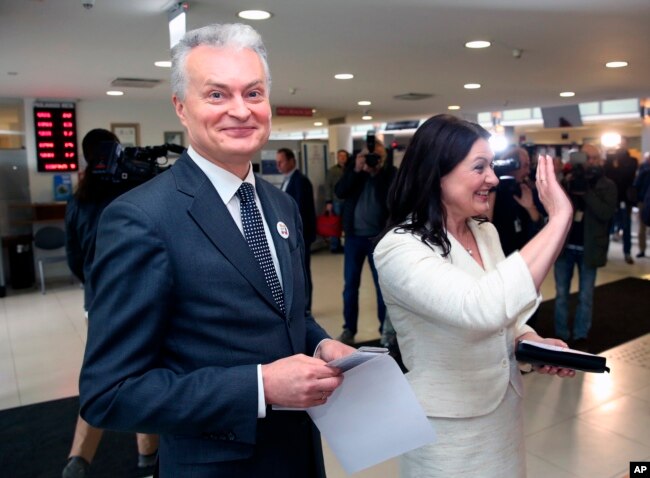 Business-minded economist Gitanas Nauseda, a presidential candidate, and his wife, Diana Nausediene, right, arrive at a polling station during the advance presidential elections in Vilnius, Lithuania, May 10, 2019.