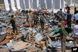 FILE - Somali soldiers filter through the debris of a destroyed building near the scene of a suicide car bomb attack in Mogadishu, Somalia, Jan, 2, 2017.