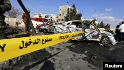 Syrian army soldiers and civilians inspect the site of a suicide bombing at a police officers' club in a residential district of Damascus, in Masaken Barza, Syria, Feb. 9, 2016. 