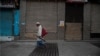 An Indian man walks past closed shops in a market during weekend lockdown to curb the spread of coronavirus in Gauhati, India, Aug. 9, 2020. 