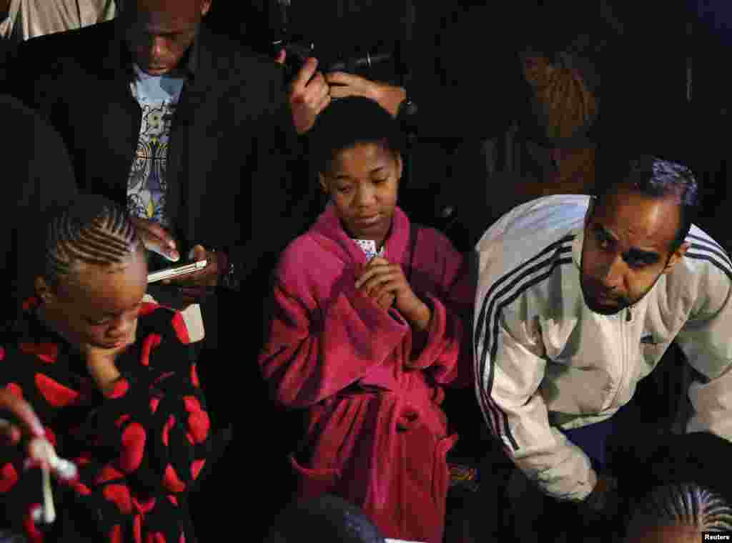 People listen to a radio as South African President Jacob Zuma announces the death of former South African President Nelson Mandela in Houghton, Dec. 5, 2013.
