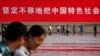 资料照：北京的行人走过天安门广场的一幅巨幅标语。（2012年6月3日）