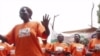 Orange-shirted women promote the health benefits of the orange sweet potato during a community performance in Uganda.