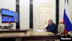 Russian President Vladimir Putin watches a test launch of the Sarmat intercontinental ballistic missile, via video link in Moscow