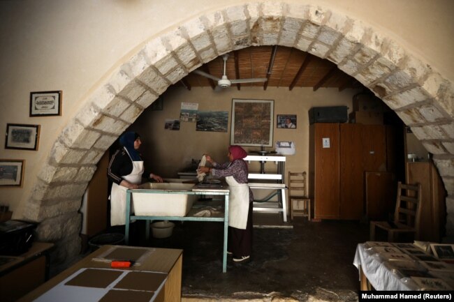 Wanita Yordania menggunakan daun tanaman yang dibuang untuk membuat kertas di Koperasi Irak al Amir di Amman, Yordania, 3 September 2020. (Foto: REUTERS/ Muhammad Hamed)