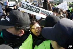 지난달 23일 한국 서울 국방부 앞에서 한국과 일본의 군사비밀정보 보호협정 체결에 반대하는 시위대가 경찰과 몸싸움을 벌이고 있다.