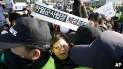 Seorang demonstran bentrok dengan polisi dalam aksi unjuk rasa menentang perjanjian pertukaran informasi intgelijen (GSOMIA) antara Korea Selatan dan Jepang di sepan kantor Menteri Pertahanan Korea Selatan di Seoul, 23 November 2016 (AP Photo/Ahn Young-joon).