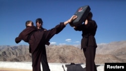 FILE - Buddhist nuns help a participant learn Kung Fu, a form of martial art, during a five-day workshop in Hemis region in Ladakh, India, Aug. 17, 2017.