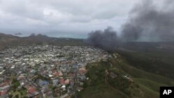 Asap membubung dari pesawat marinir Osprey setelah mendarat secara darurat di Markas Angkatan Udara Bellows, dekat Waimanalo. Hawaii (17/5). (AP/Brandon Kelly)