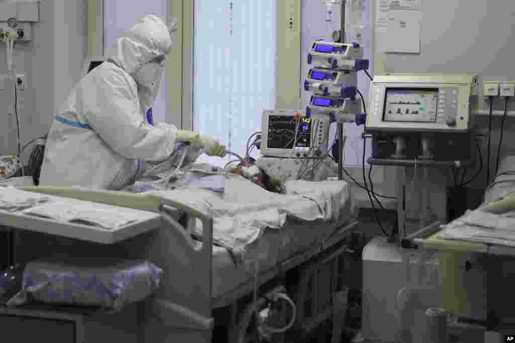 A medical working wearing a special suit to protect against COVID-19 treats a patient with coronavirus at an ICU at the Regional Clinical Hospital 1, in Krasnodar, south Russia.